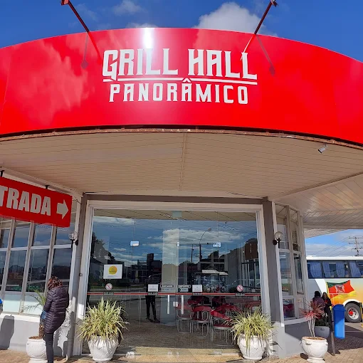Entrada do Grill Hall Panorâmico, com toldo vermelho e ônibus estacionado ao lado